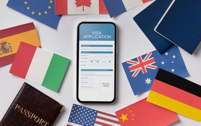 tabletop with various country flags and a blank visa application open on a phone
