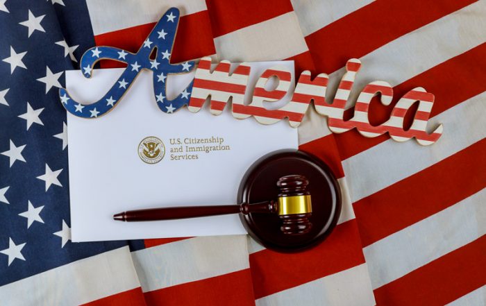 American flag in background with an envelope with US Citizenship and Immigration Services addressed on top